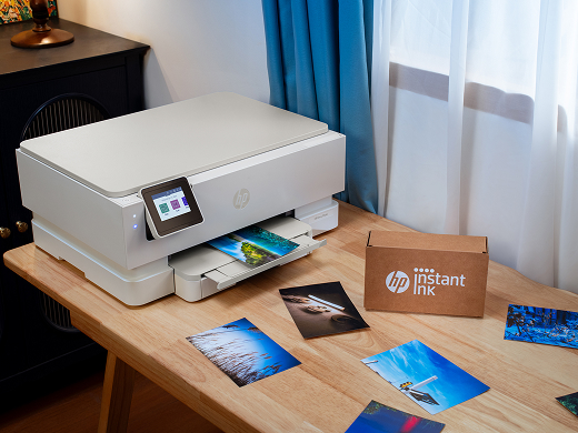 Person printing photos on HP printer at home office desk